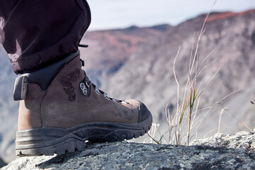 young woman hiker legs on mountain peak cliff