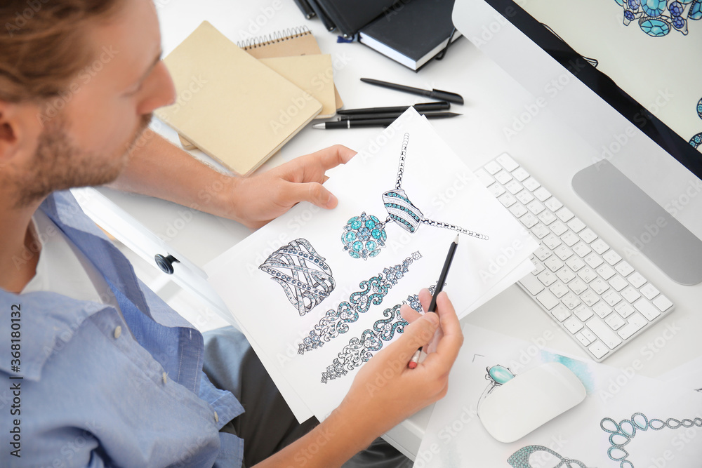 Male jewelry designer working in office