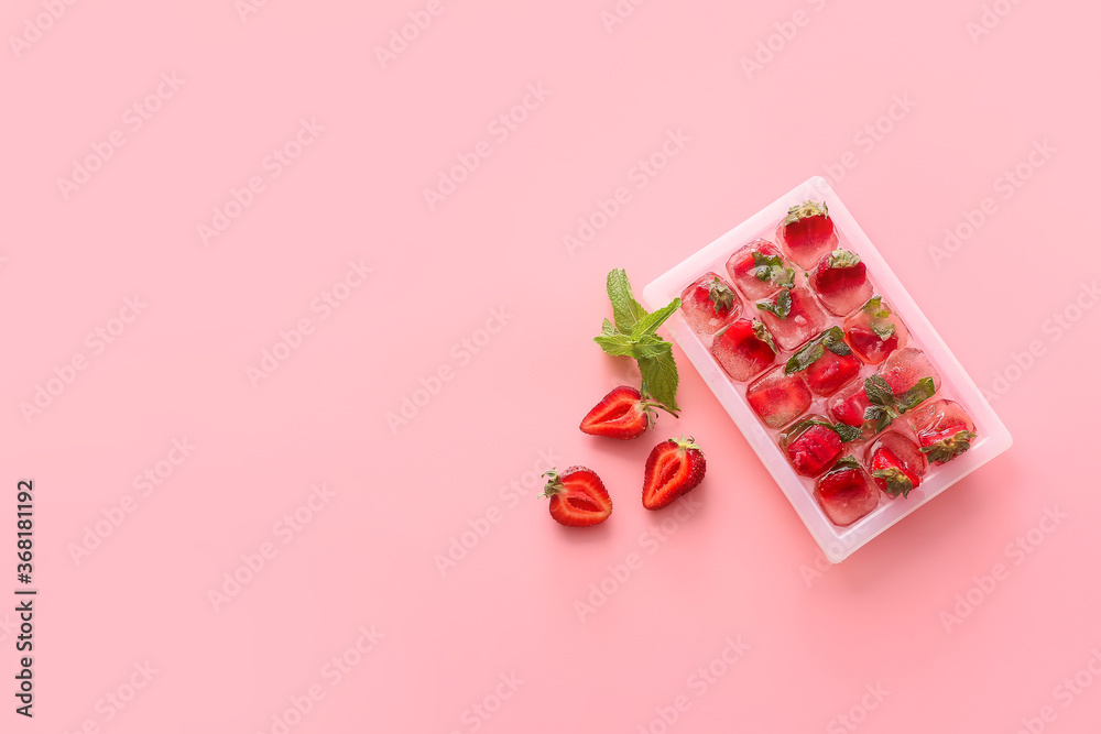 Tray with berries in ice on color background - obrazy, fototapety, plakaty 