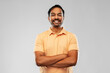 people and furniture concept - portrait of happy smiling young indian man with crossed arms over grey background