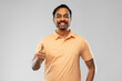 © Syda Productions - people and furniture concept - portrait of happy smiling young indian man showing thumbs up over grey background