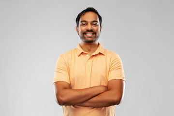 people and furniture concept - portrait of happy smiling young indian man with crossed arms over gre