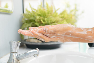  Hands of girl use soap and washing under the water tap. Hygiene concept hand detail. woman washing hands with soap over sink in bathroom.