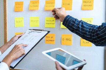 Poster - Two creative meeting and planning use post it notes on board to share idea