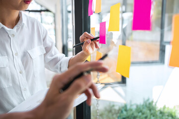 Poster - Young creative team using post it notes in glass wall to writing strategy plan