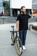© F8  \ Suport Ukraine - Young hipster bearded man with fixed gear bike waving hand on city street