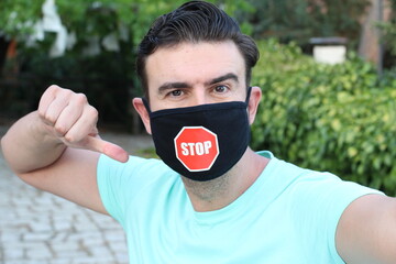 Wall Mural - Young man wearing protective face mask with stop sign 