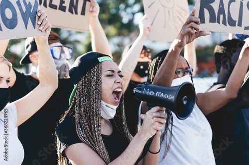 People from different ages and races protest on the street for equal rights - Demonstrators wearing face masks during black lives matter fight campaign - Main focus girl\'s face holding megaphone