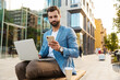 © Drobot Dean - Confident male manager with laptop and smart phone