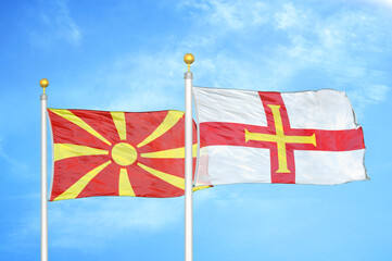 North Macedonia and Guernsey two flags on flagpoles and blue sky