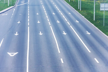 Four paved lanes with traffic arrows directing traffic in various directions, dedicated bus lane.