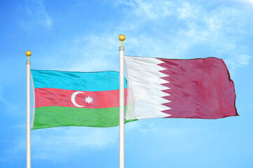 Azerbaijan and Qatar two flags on flagpoles and blue sky