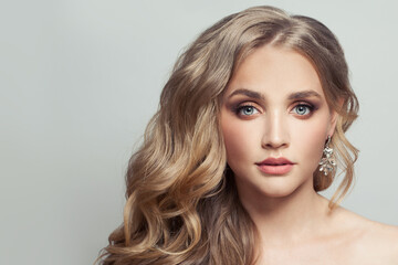 Wall Mural - young healthy woman with long blonde curly hair on white