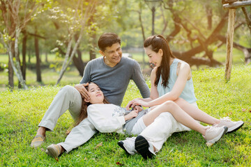 Asian family are happy to picnic, do the lifestyle of parent and daughter in the park. Learn about nature during the long summer holidays with good weather. Concept Health insurance COVID-19