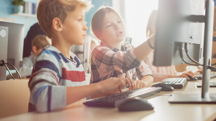Elementary School Computer Science Classroom: Portrait of Smart Girl, Boy Working Together and using Personal Computer, Learning Informatics, Internet Safety, Programming Language for Software Coding