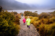 © Scott Murray/Austockphoto - Children in bright rain jackets running down path on overcast day