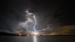 © Scott Murray/Austockphoto - View of lightning over factory with ocean in foreground at night