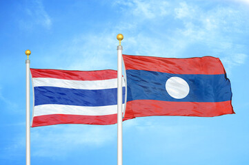 Thailand and Laos. two flags on flagpoles and blue sky