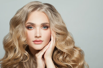 Wall Mural - lovely woman model face with long healthy blonde curly hair on white