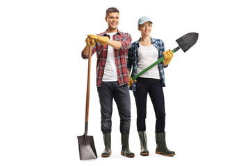 Poster - Full length portrait of young couple gardeners standing with shovels