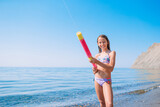 Fototapeta Morze - Adorable active little girl at beach during summer vacation