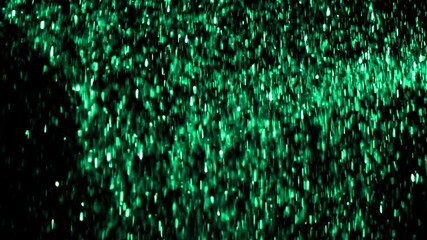 Green glitter particles falls against black background shot in slow motion at 480fps 