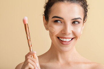 Poster - Beautiful young woman with foundation on her face against color background