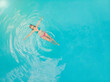 © Rodrigo Lucentini - Aerial view of a relaxed young woman in the transparent turquoise sea. Top view of slim woman relaxing in hotel pool.