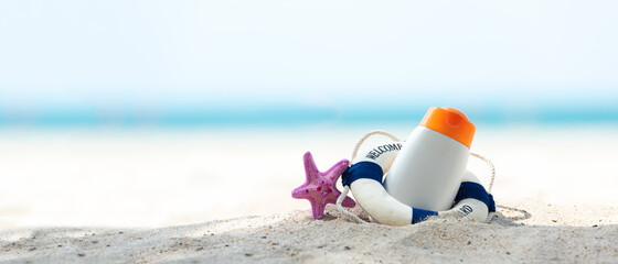 Protective sunscreen or sunblock and sunbath lotion in white plastic bottles with sandals on tropical beach 