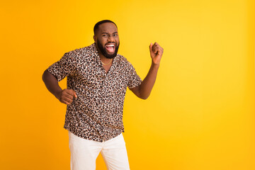 Wall Mural - Photo of crazy funny dark skin guy good mood raise fists celebrating success lottery rich person wear golden necklace trend leopard shirt white shorts isolated bright yellow background