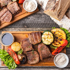 Canvas Print - Delicious grilled beef tongue with garnish on wooden board.  Top view