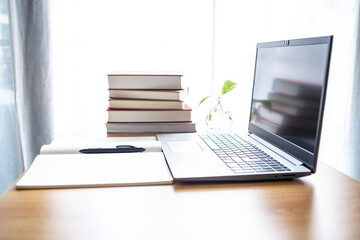 Laptop and book study materials on the desk