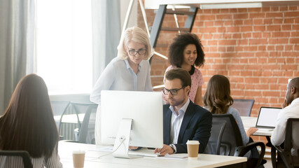 Poster - Mature businesswoman mentor helping employee with corporate software, training staff, using computer, team leader giving instructions to subordinate, diverse colleagues working in shared workspace