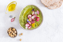Colorful Green Hummus Bowl With Baked Radish And Edible Flowers, Vegetarian Meal, Top View