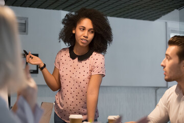 Canvas Print - Mixed race businesswoman mentor holding briefing with employees, training staff close up, lecturer speaker explaining strategy, presenting project results at meeting, business partners negotiations