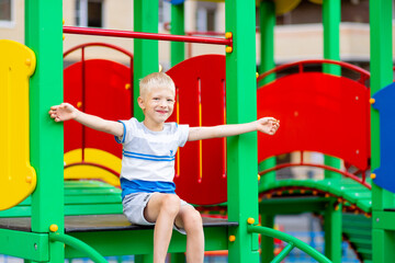 happy baby boy 5-6 years old playing on the Playground in the yard in the summer. Children's lifestyle