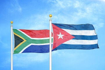 South Africa and Cuba two flags on flagpoles and blue sky