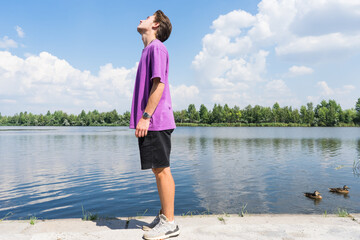 young man relaxing and doing gymnastic exercises outdoors. Sport and healthy lifestyle.