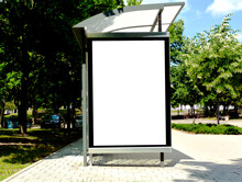 White Poster And Commercial Ad Space Display Lightbox Mockup Base. Composite Image. Blank Ad Panel. Bus Shelter And Bus Stop. Glass Design. Urban Park Setting. Green Background