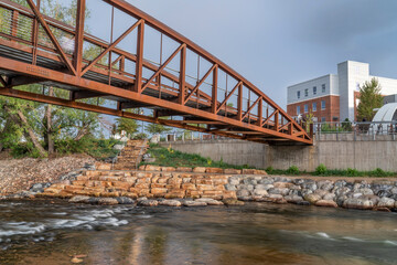 Wall Mural - bike trail and footbridge - Cache la Poudre River at whitewater park in downtown of Fort Collins Colorado with Powerhouse Energy Campus of Colorado State University in background