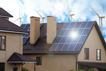 wind turbines near house with installed solar panels on roof. alternative energy source