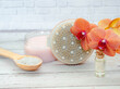 
Cosmetics - anti-cellulite scrub, sea salt and dry massage brush with orchid flower on studio background