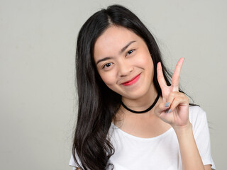 Portrait of young beautiful Asian woman against white background