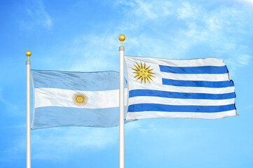 Wall Mural - Argentina and Uruguay two flags on flagpoles and blue sky