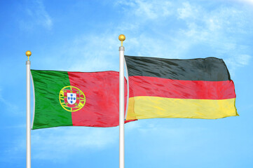 Canvas Print - Portugal and Germany two flags on flagpoles and blue sky