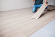 © andrey gonchar - Man in jeans on a new laminate floor - wood floor decor - laminate laying master