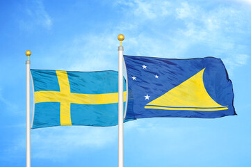 Sweden and Tokelau two flags on flagpoles and blue sky