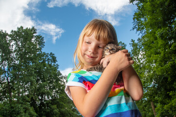 Wall Mural - Young girl holding pet tabby kitten