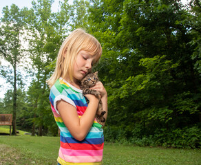 Wall Mural - Young girl holding pet tabby kitten