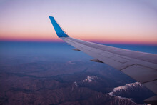 Boeing 737 Wing. Dawn In The Sky Over Snow-capped Mountains.  Flight Over Afghanistan.